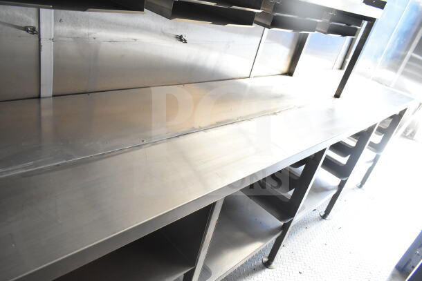 Rock Solid Cargo 8.5'x28' food trailer interior, featuring stainless steel counters and a CaptiveAire grease hood. Mint condition.