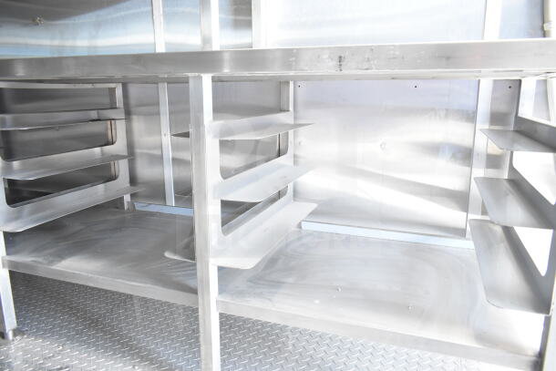 Rock Solid Cargo 8.5'x28' food trailer shell interior with CaptiveAire grease hood. Ready for custom outfitting. Durable metal shelving and floors.