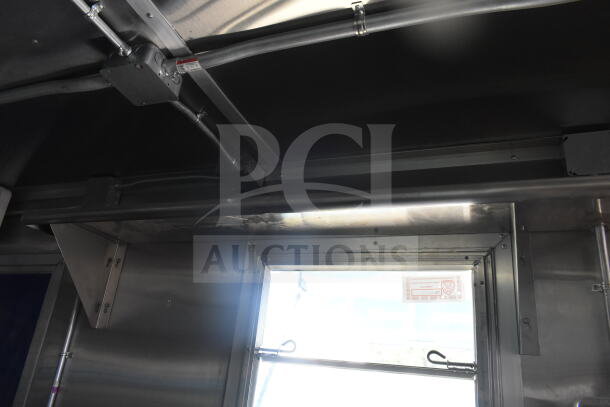 Rock Solid Cargo 8.5'x28' food trailer interior with CaptiveAire grease hood, ready for customization. Durable metal finish.