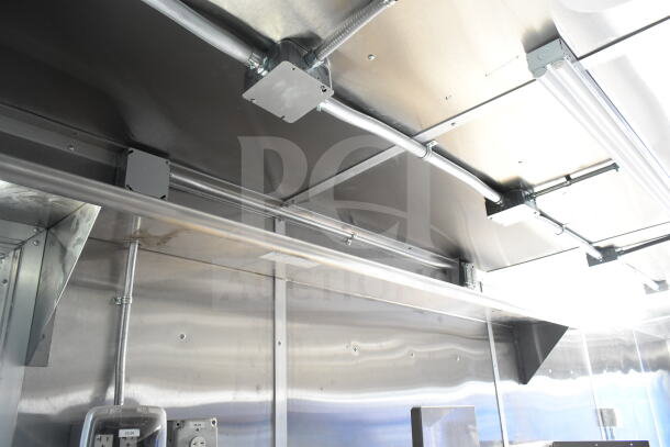 Rock Solid Cargo 8.5'x28' food trailer interior with CaptiveAire grease hood. Stainless steel finish, ready for customization.