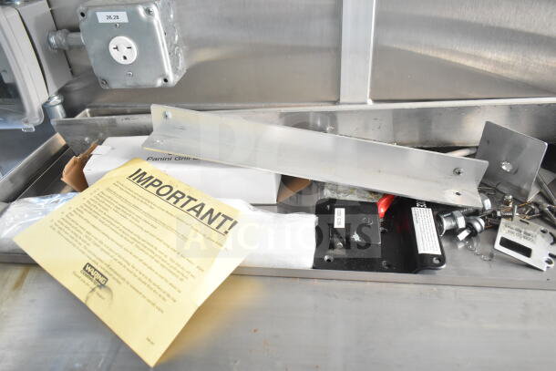 "Rock Solid Cargo food trailer shell interior, featuring CaptiveAire grease hood, electrical outlet, and mounting hardware. Includes important notice sheet."