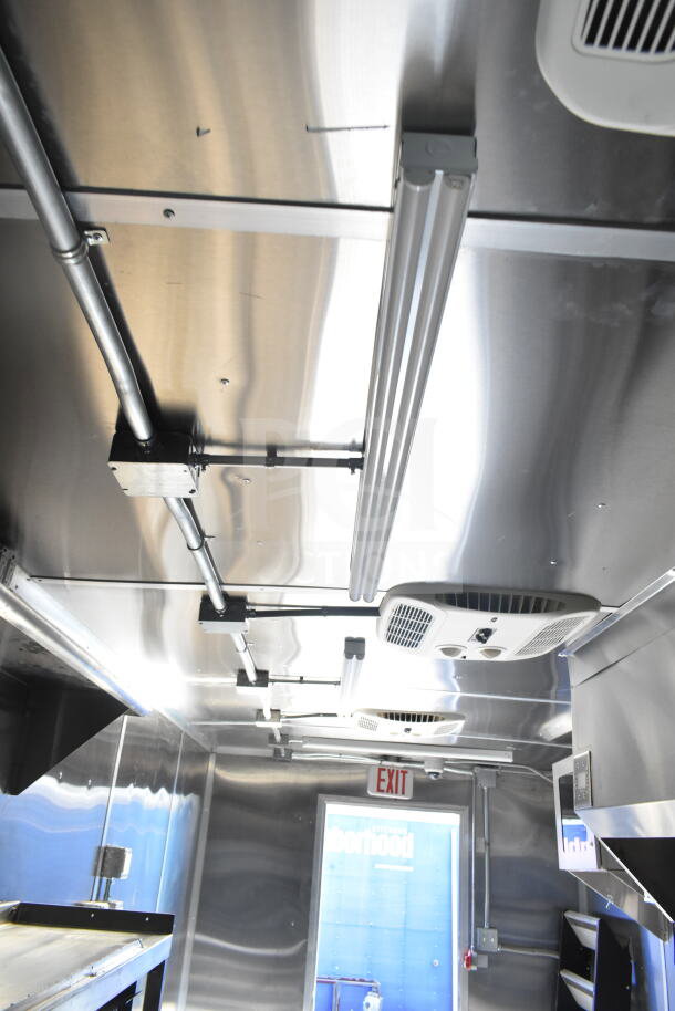 Interior view of Rock Solid Cargo 8.5'x28' food trailer shell, featuring CaptiveAire grease hood and stainless steel finish. Ready for outfitting.