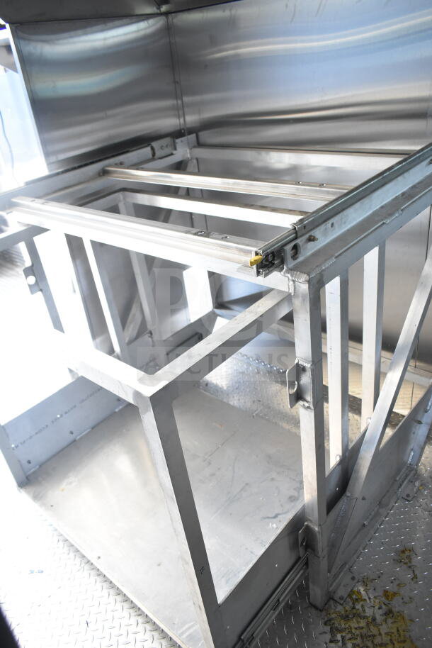 Rock Solid Cargo 8.5'x28' food trailer shell with CaptiveAire grease hood, ready for outfitting. Sturdy metal framework visible.