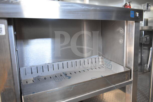 Rock Solid Cargo 8.5'x28' food trailer interior with CaptiveAire grease hood, stainless steel surfaces, ready for outfitting.
