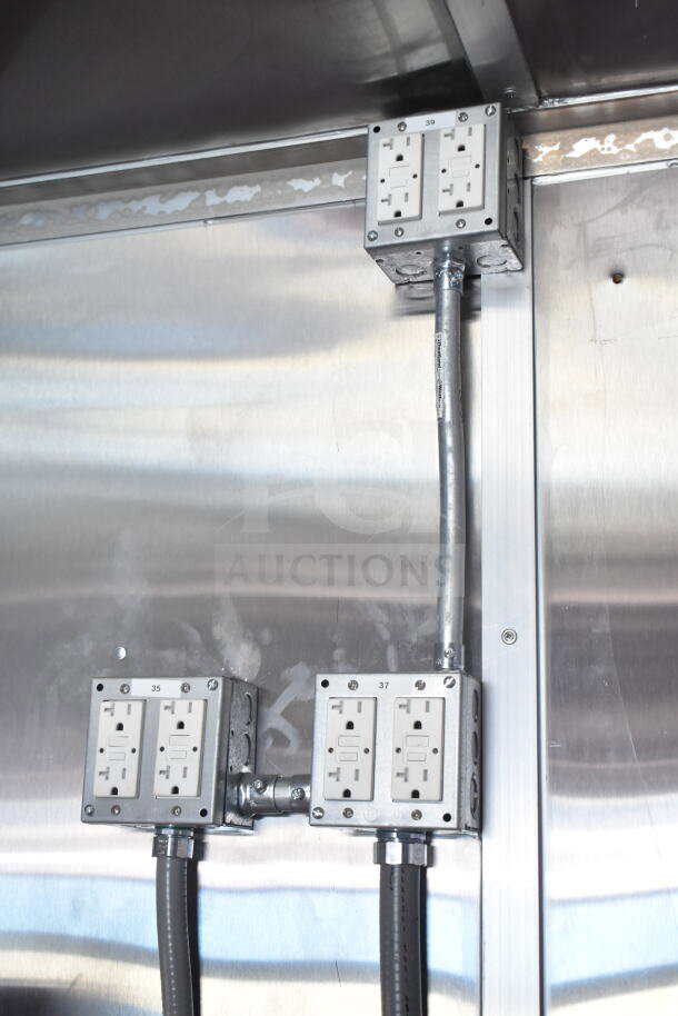Rock Solid Cargo 8.5'x28' food trailer interior with electrical outlets and metal surface. CaptiveAire grease hood included.