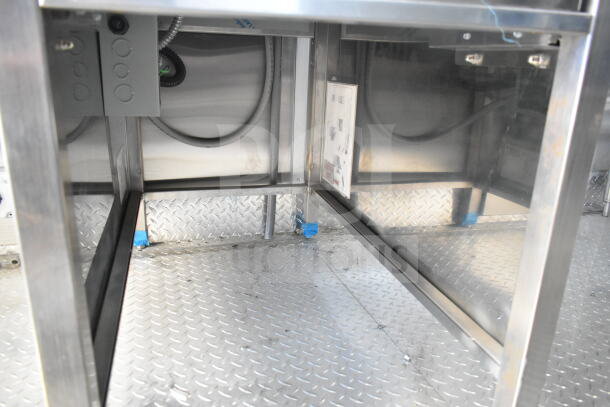 Rock Solid Cargo 8.5'x28' food trailer interior with CaptiveAire grease hood. Stainless steel construction, electrical panel visible.