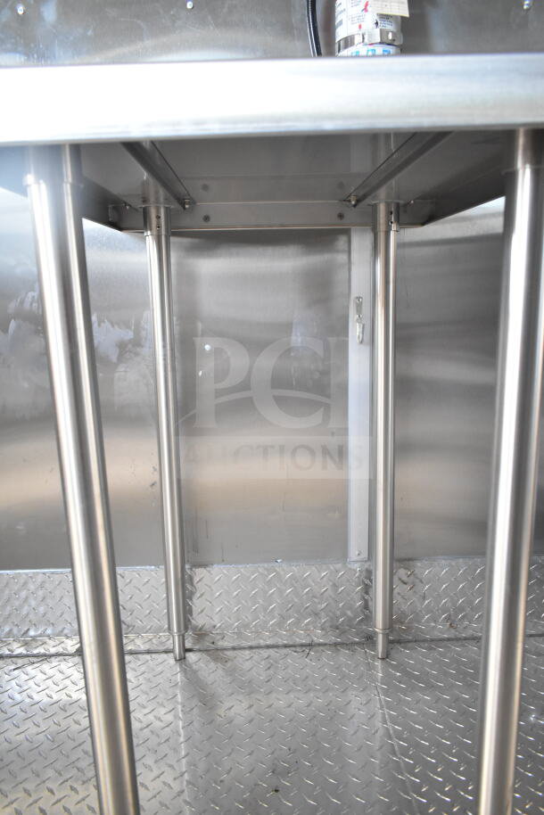 Interior view of Rock Solid Cargo 8.5'x28' food trailer shell, featuring a CaptiveAire grease hood and diamond plate flooring.