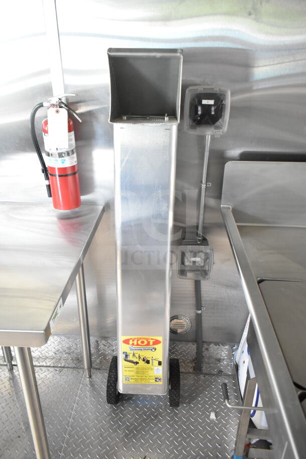 Interior of Rock Solid Cargo 8.5'x28' food trailer with CaptiveAire grease hood, stainless steel surfaces, and fire extinguisher.
