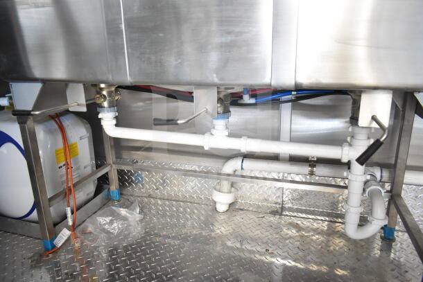 Rock Solid Cargo 8.5'x28' food trailer interior showing stainless steel plumbing and piping on diamond plate flooring.