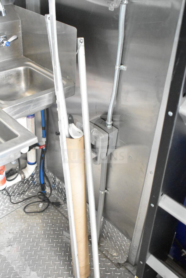 Rock Solid Cargo 8.5'x28' food trailer shell interior, showcasing stainless steel sink and piping. Features CaptiveAire grease hood.