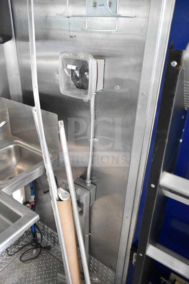 Interior view of a Rock Solid Cargo 8.5'x28' food trailer shell, featuring a CaptiveAire grease hood. Visible wiring and plumbing.