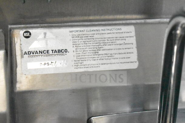 Label on stainless steel with Advance Tabco logo and cleaning instructions for maintaining sink quality.