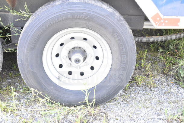 Rock Solid Cargo trailer tire with GrandTrailer N'007 markings, size ST235/80R16, parked on gravel.