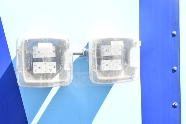 Electrical outlets with protective covers on a blue surface.