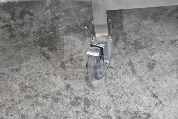 Close-up of a commercial caster on a Turbochef HCW2620 rapid cook oven. Metal frame, gray wheel on concrete.