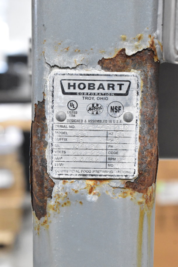 Hobart 6801 meat saw label showing model details, voltage, and phase; visible rust and wear on metal.