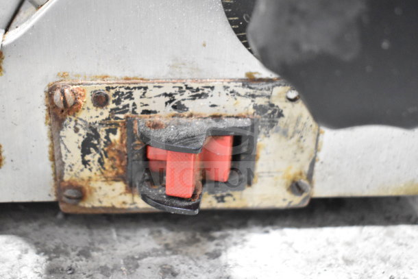 Globe Commercial Countertop Meat Slicer switch with visible wear, rust spots, and red safety switches. 115 volts, 1 phase.