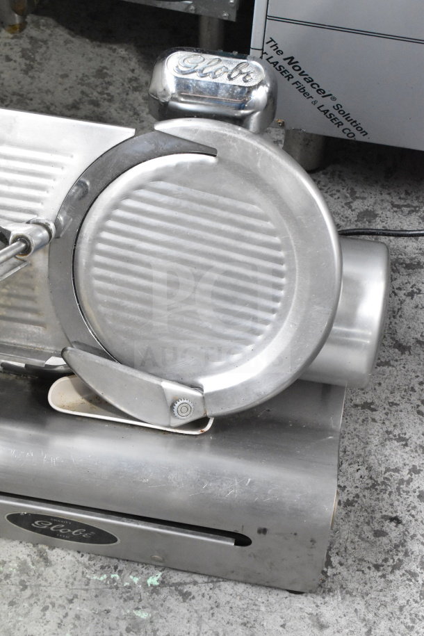Globe Commercial Countertop Meat Slicer with blade sharpener, 115 volts, 1 phase, metallic finish, with logo visible.