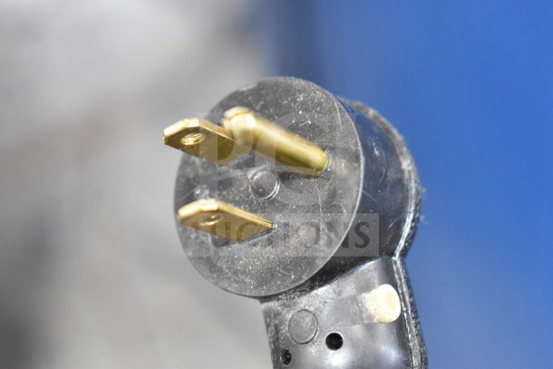 Close-up of a power plug for F'real FRLB4 milkshake mixer, showing metal prongs. Screen reportedly does not power on.