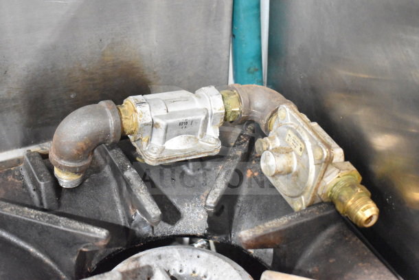 Garland SunFire X36-6R commercial gas range burner detail, showing piping and fittings. Parts appear used with visible wear.