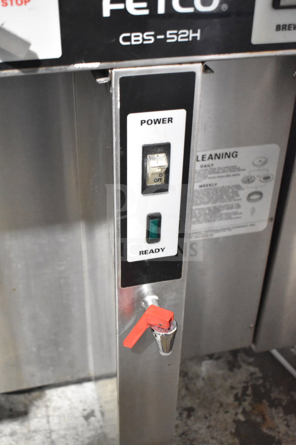 Fetco CBS-52H15 commercial double coffee machine, stainless steel, with power toggle, indicator lights, and red lever.