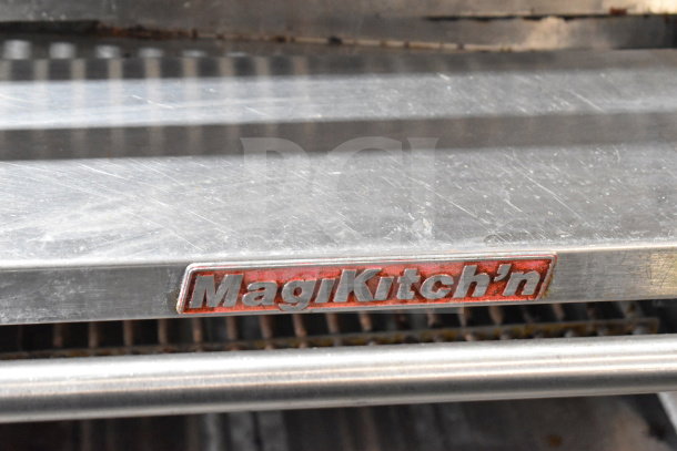 MagiKitch'n commercial charbroiler grill on stand with shelf and casters. Brand name plaque visible.