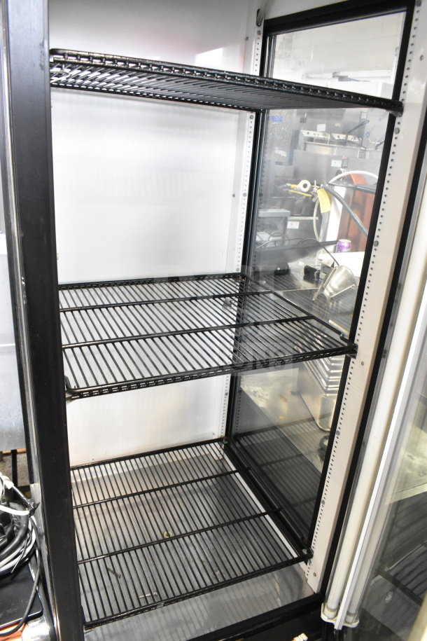 True GEM-23 commercial single-door reach-in cooler merchandiser. Features black shelving, clear glass door, 115 volts, 1 phase.