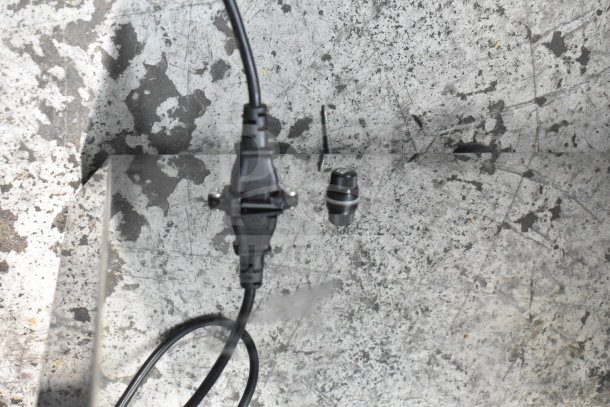 Close-up of Vevor 2000E4 Commercial Citrus Juicer cord and attachment on a textured surface. Electric, 110V, 1 Phase.