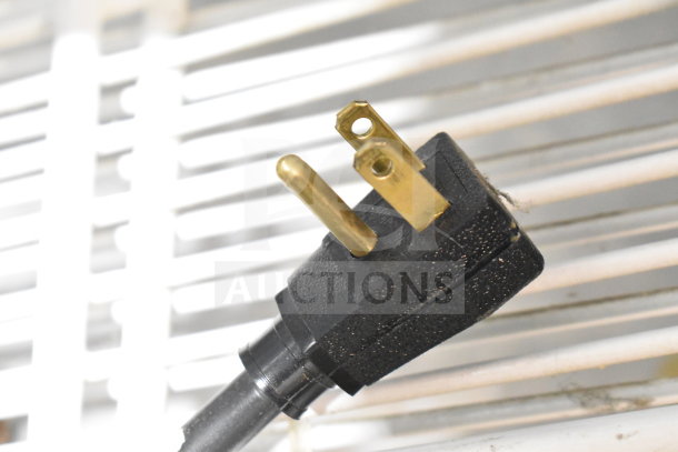 Close-up of a power plug for True GDM-72-LD Cooler Merchandiser, showing three-prong design against a vented surface.