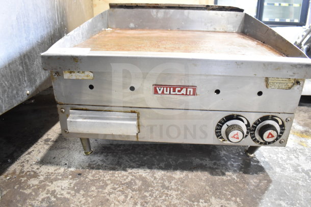 Vulcan commercial gas flat top griddle, countertop model, showing control knobs and wear on cooking surface.