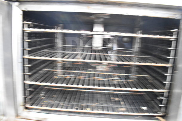 Vulcan SG4D-4 commercial convection oven interior with multiple racks, view-through doors, thermostatic controls, on casters.