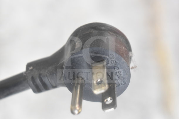 Close-up of a black electrical plug from the 2021 True GDM-26-HC Cooler Merchandiser. Marked "Ching Cheng."