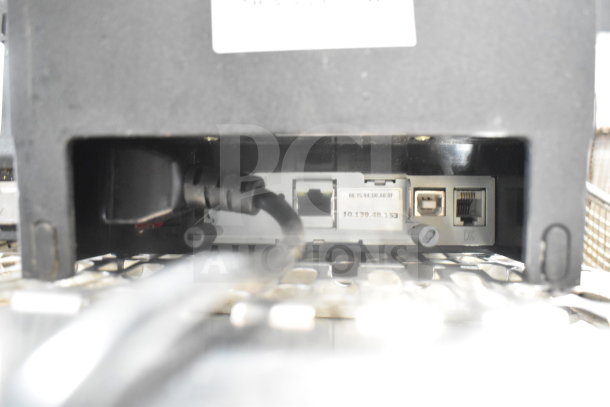 Close-up of a POS monitor connection ports with visible cables, showing various input options.