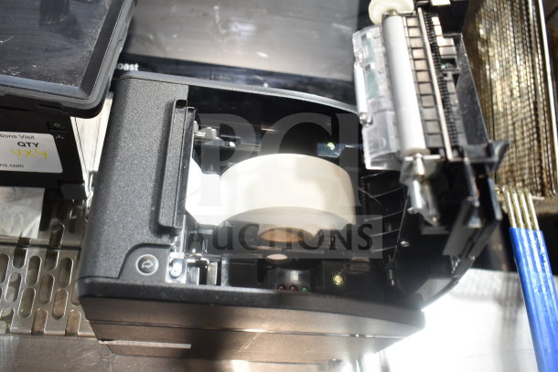 POS monitor and open Bixolon SRP-S300 receipt printer showing paper roll. Includes signage stating "QTY x4".
