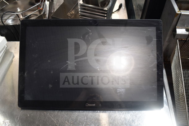 POS monitor with "Toast" logo visible, used condition with visible smudges on screen, part of a multi-item auction lot.