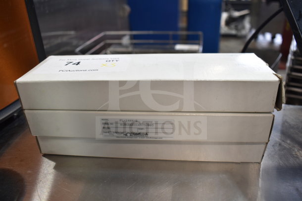 Three Omega FL-1455-G flowmeters in original boxes, shown stacked. Boxes marked with model and serial numbers.