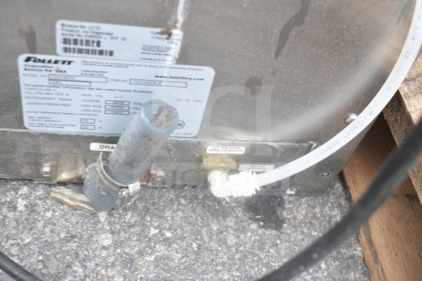 Follett 12CI400A commercial countertop ice and water dispenser, showing back panel with water and drain connections.