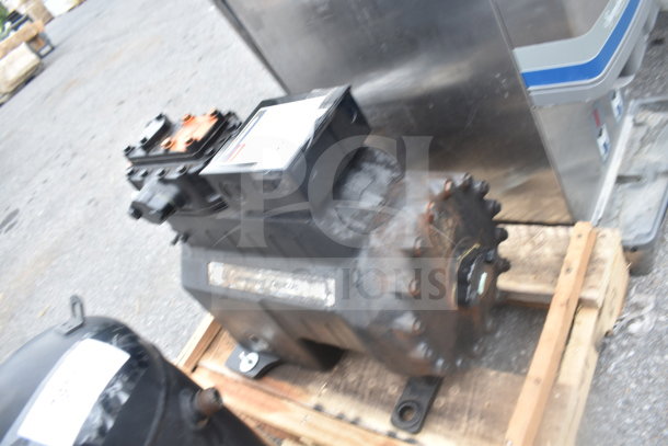 Copeland Discus 3DKHA120L-TFD-227 compressor on pallet, showing rust and wear. Label visible on top indicating model and specs.