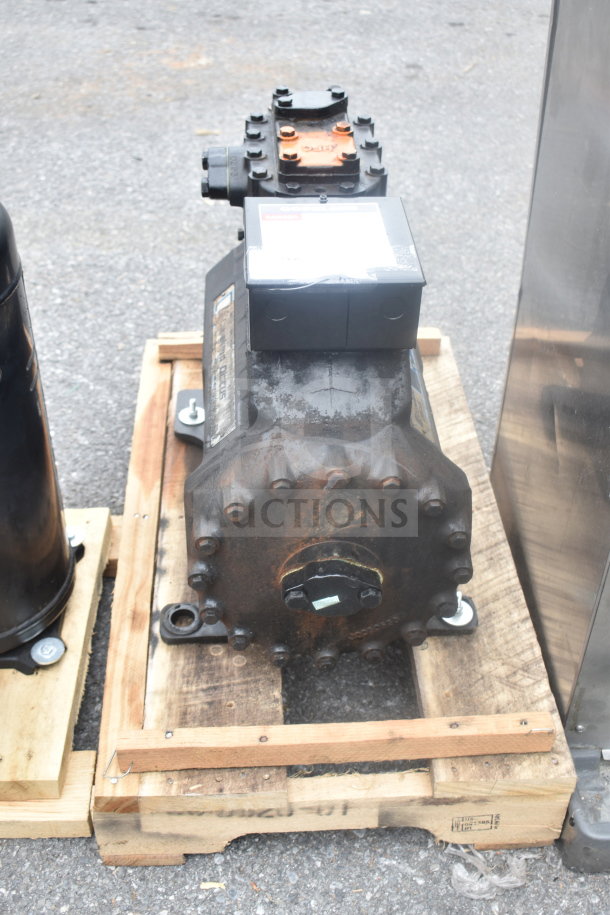 Copeland Discus 3DKHA120L-TFD-227 Compressor, showing some wear, on a pallet. Industrial-grade, suitable for cooling systems.