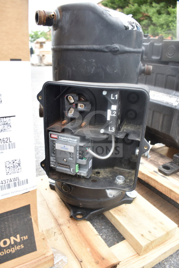 Emerson ZF34K5E-TFD-260 3-phase compressor on pallet. Features electrical connections and Copeland Scroll diagnostics.