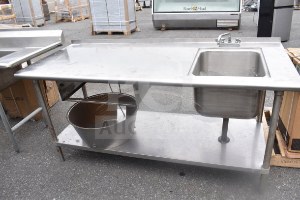 Commercial stainless steel table with sink bay, faucet, and durable under shelf. Used condition with visible wear.