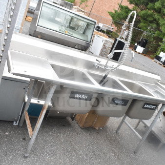 Advance Tabco commercial 3 bay sink with dual drain boards, labeled "Wash," "Rinse," "Sanitize," with pre-rinse faucet.