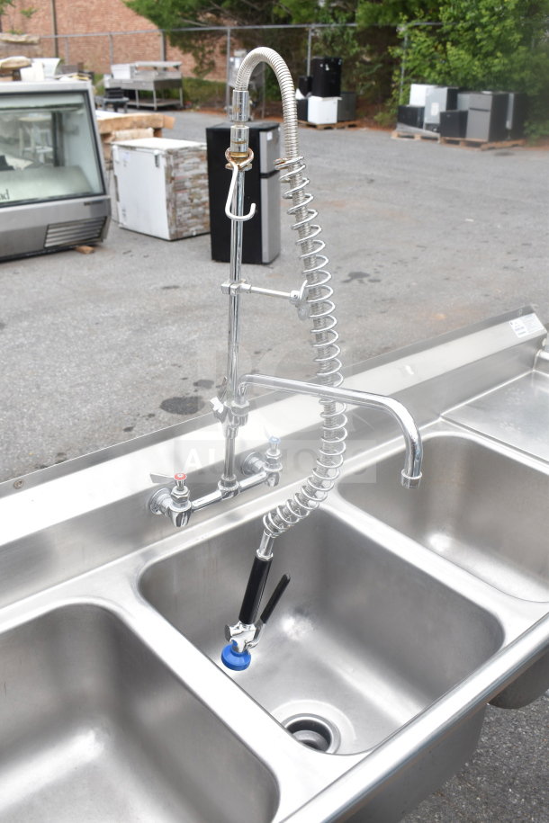 Advance Tabco commercial 3 bay sink with dual drain boards, durable stainless steel, includes high-arc faucet and sprayer.