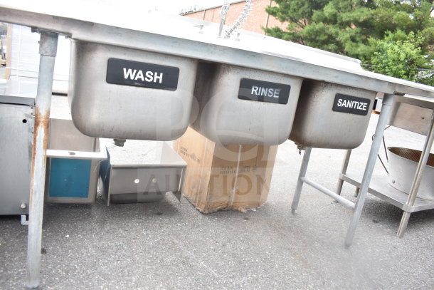 Advance Tabco commercial 3 bay sink with dual drain boards. Features labeled wash, rinse, sanitize compartments, used condition.