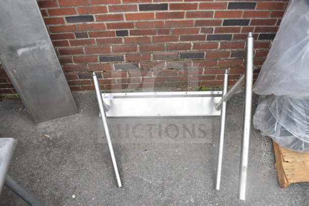 Metal legs set against a brick wall, featuring a sturdy rectangular base and cylindrical supports, in good condition.