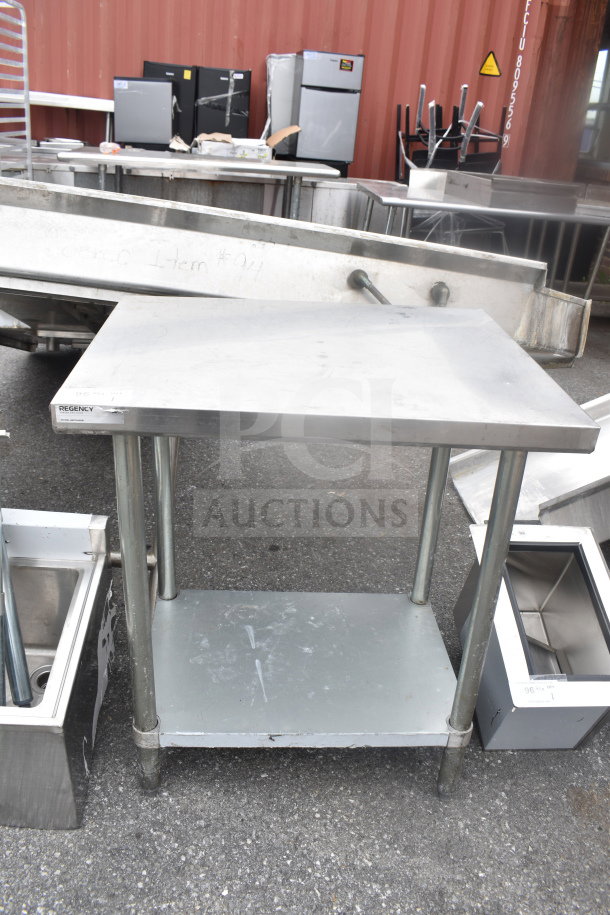 Regency stainless steel table with under shelf, sturdy legs, minor wear, visible brand label, ideal for kitchen use.