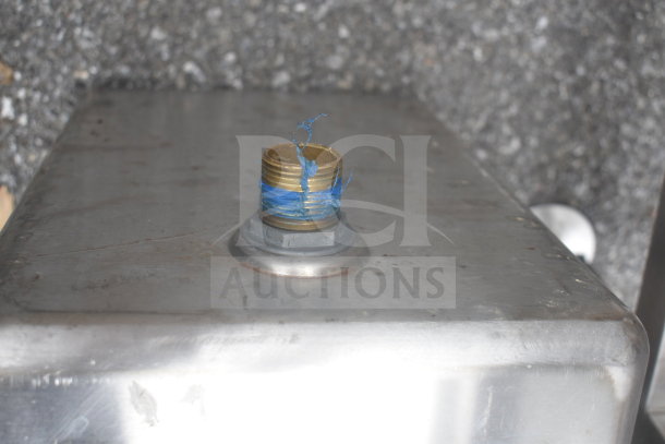 Metal Drop In Bay with brass threaded fitting wrapped in blue tape. The surface shows signs of wear.