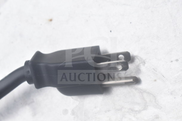 Close-up of a standard black three-prong electrical plug lying on a white surface.