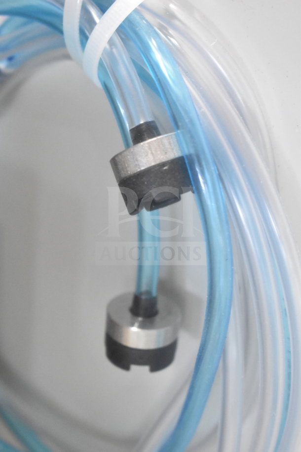 Close-up of tubing and fittings for the 2025 Noble 495LTUC24 undercounter dishwasher, highlighting internal components.