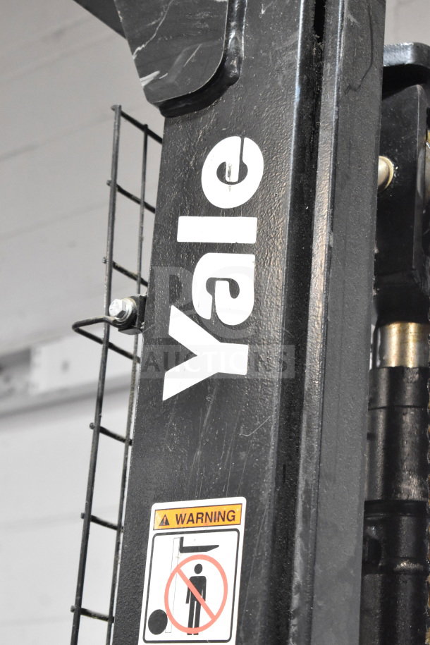 Yale E Industrial Walkie Stacker, branded "Yale" on black metal. Visible warning label indicates safety instructions.